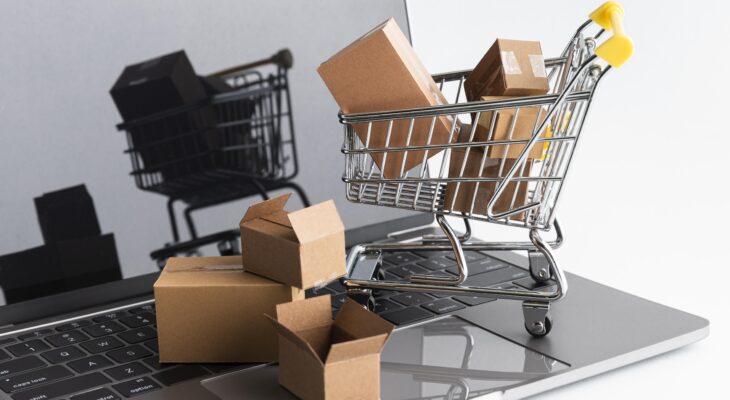 Model wózka zakupowego wypełnionymi kartonami na laptopie.